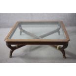An Empire style coffee table with shaped bevelled plate glass top on cross stretchered base. H.44