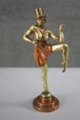 An Art Deco style patinated brass figure of a burlesque dancer with top hat. Mounted on a copper