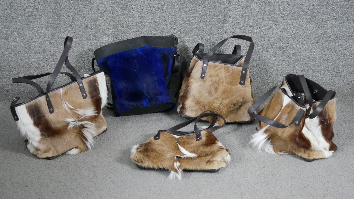 Five Caroline Burns goat skin and leather hand bags, one dyed dark blue, each with designer label to