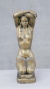 A large brass figure of a nude kneeling woman with arms above her head. H.47 W.13 D.24cm