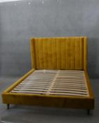 A contemporary upholstered bedstead to take a kingsize mattress. H.129 W.165 D.219 cm