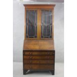 An Edwardian mahogany bureau bookcase with astragal glazed upper section above quarter veneered fall