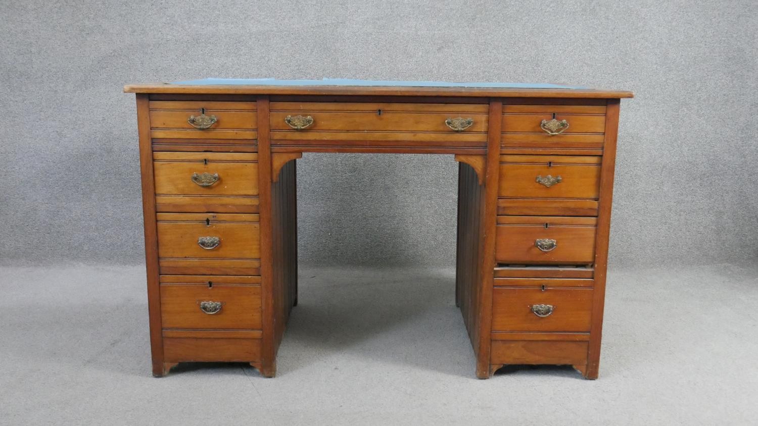 A late 19th century walnut pedestal desk with an arrangement of nine drawers on stile supports. H.66