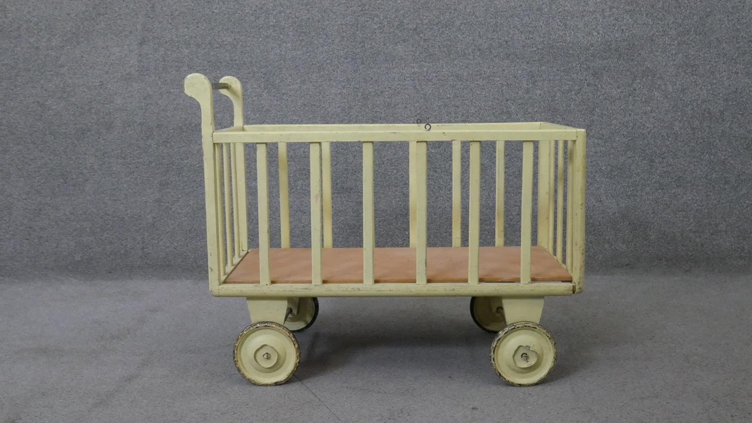 A vintage painted child's toy trolley or doll's pram. H.58 W.75 D.34 cm