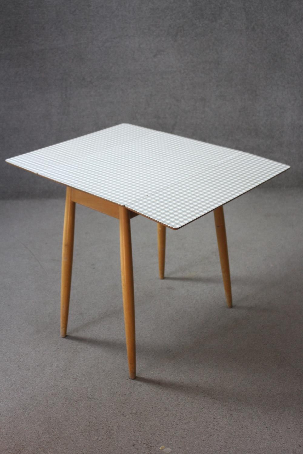 A mid century vintage drop flap kitchen table with gingham check laminated top. H.74 W.89 D.68 cm. - Image 7 of 11