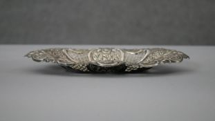 A Victorian pierced repousse design silver pin dish with floral and scrolling motifs and pierced