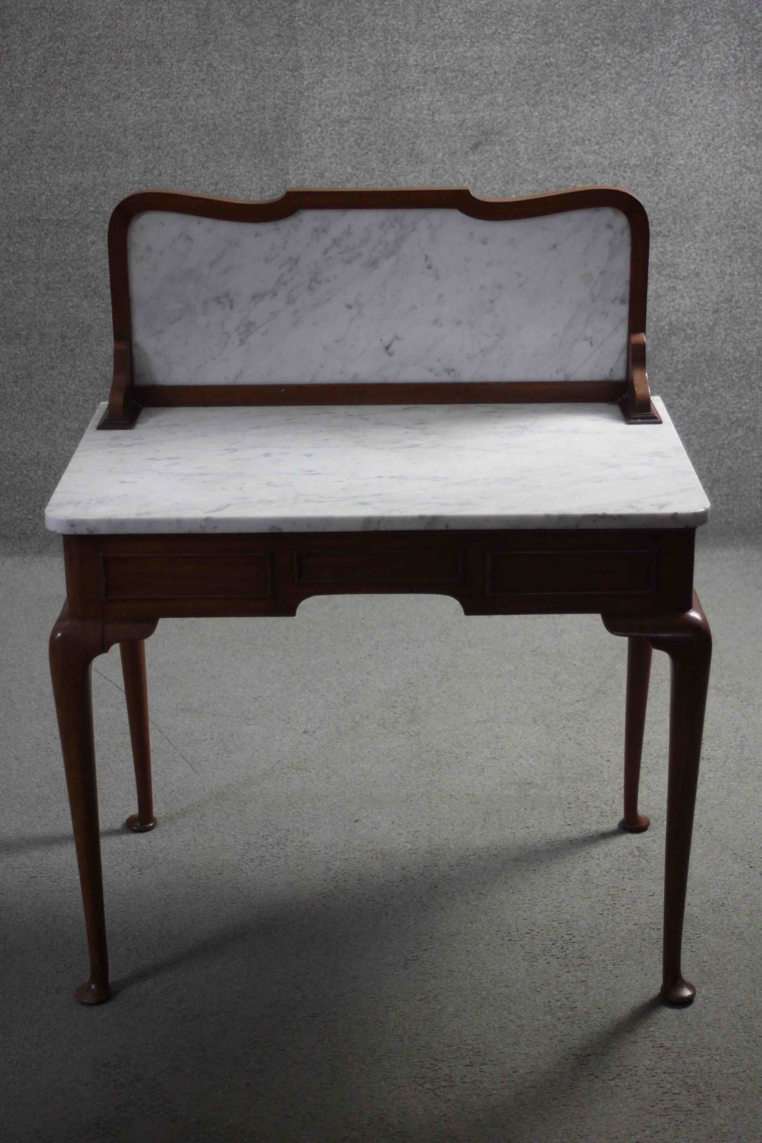 A C.1900 mahogany washstand with marble back and top on slender cabriole pad foot supports. H.104