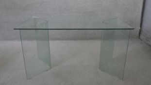 A vintage tempered glass top table raised on twin curved glass pedestals. H.75 W.140 D.70 cm