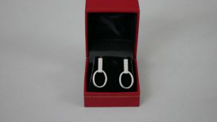 A pair of white metal (tests as platinum) and diamond articulated stirrup earrings with butterflies.