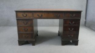 A Georgian style mahogany three section pedestal desk with inset gilt tooled leather top on