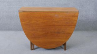 A vintage teak drop flap dining table on shaped gateleg supports. H.75 W.167 D.98 cm (extended)