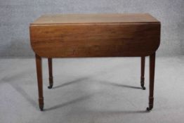 A Georgian mahogany drop flap Pembroke table fitted with a pair of frieze drawers on square tapering