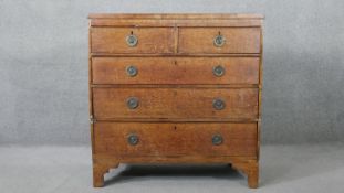 A Georgian oak and mahogany crossbanded chest of drawers on bracket feet. H.106 W.104 D.46 cm