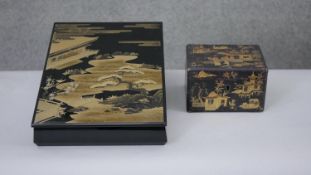 Two Japanese gilded lacquered boxes. One a tea caddy with partitions decorated with a village
