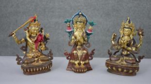 Three Tibetan gilded copper figures with hand painted detail and inlaid with coral and turquoise.