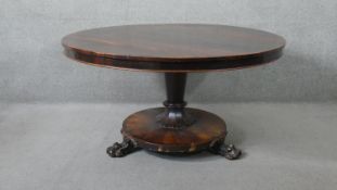 A William IV rosewood dining table on inverted tapering pedestal raised on platform base with carved