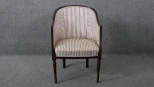 A 20th century mahogany framed Regency style tub chair on fluted tapering supports.