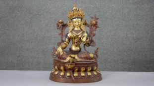 A large 20th century hand painted and gilded copper green Tara figure with hand painted details