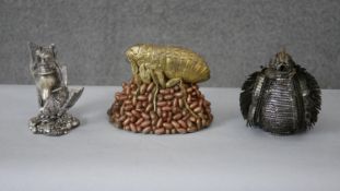 A gilded resin model of a flea on a pile of eggs along with a silvered covered model of a blue tit