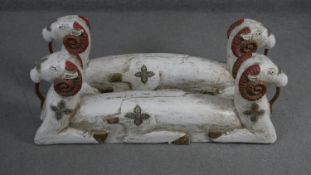 A pair of Eastern carved and painted double headed rams with inlaid mirror mosaic motifs. H.38 W.100