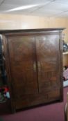 An 18th century Continental oak armoire with lozenge parquetry panel doors on stile supports. H.