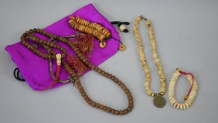 A collection of Tibetan prayer beads. Two strings of Yak bone beads, a set of wooden prayer beads