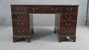 A Georgian style mahogany pedestal desk with inset tooled leather top on bracket feet. H.75 W.136