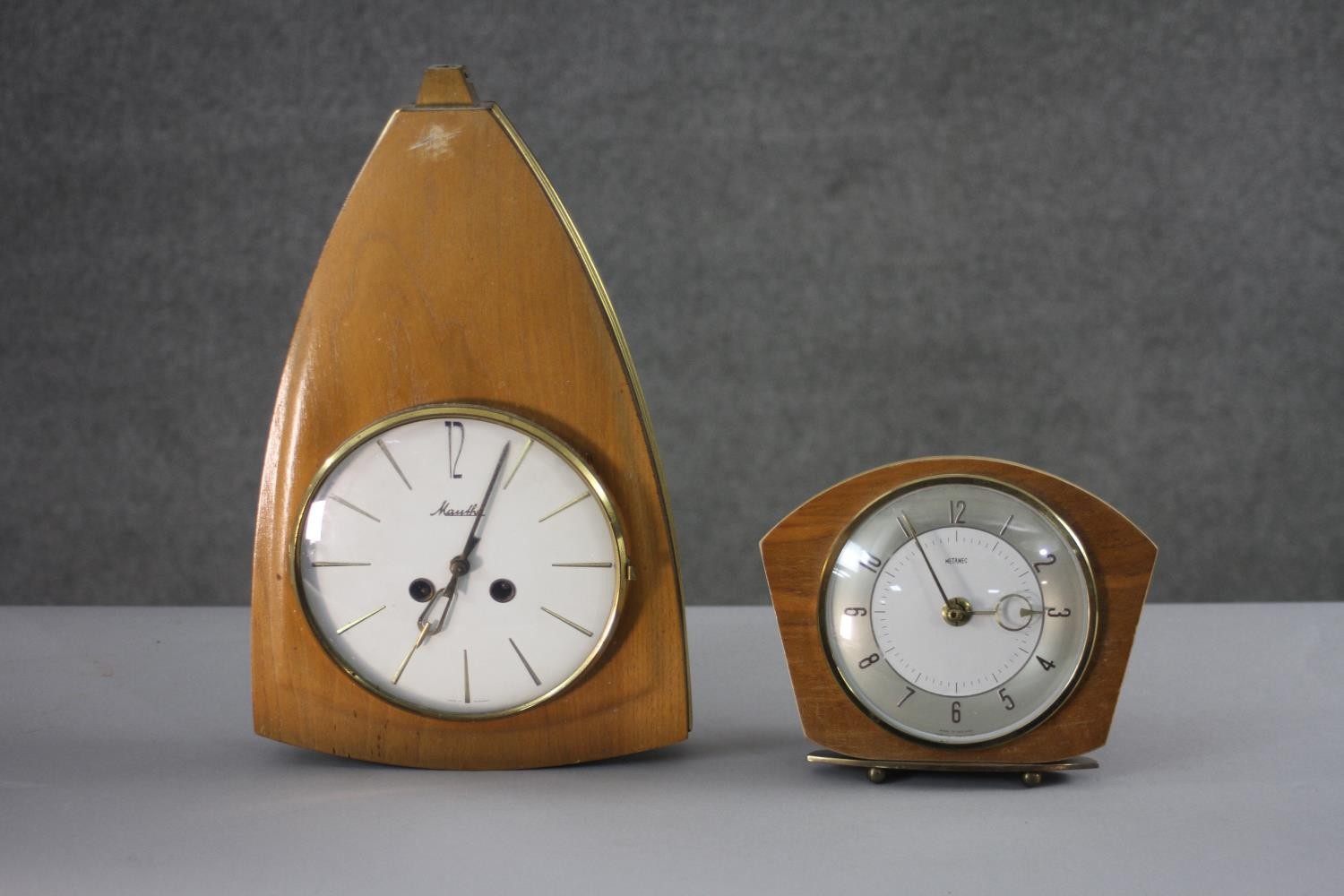 Two mid century teak clocks. One by Metamec. H.31 W.20 (largest)
