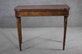 A late Georgian mahogany fold over top tea table with double gateleg action on turned tapering