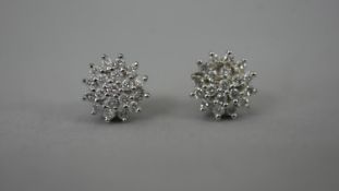 A pair of 9 carat white gold diamond stud cluster earrings with white metal butterflies. Each