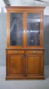 A 19th century walnut library bookcase with dentil cornice above glazed doors enclosing