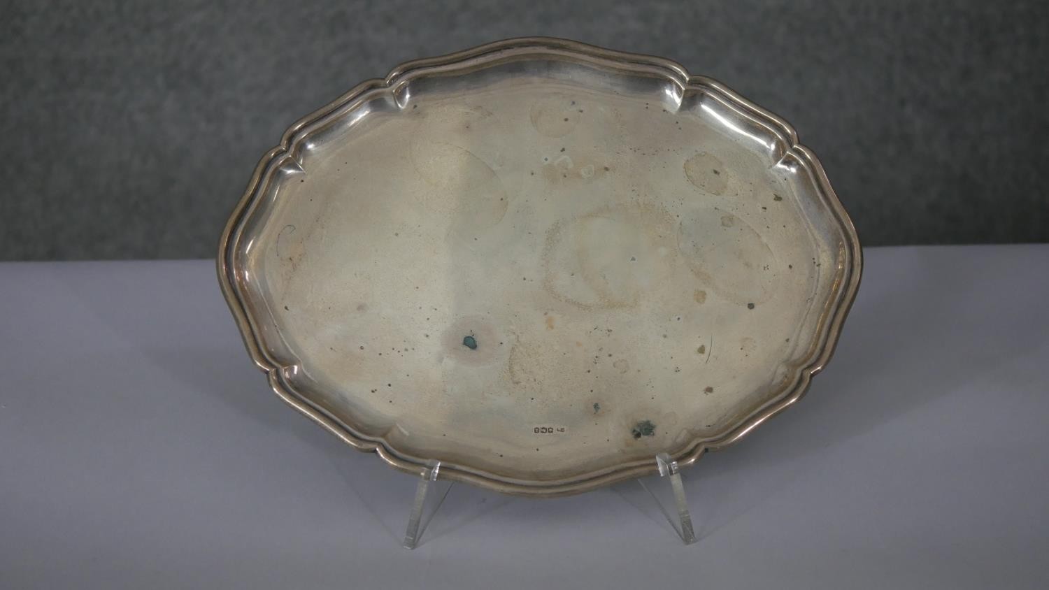 An oval scalloped edge silver serving tray. Hallmarked: HH, 1918, Sheffield. Weight 442g L.31 W.24cm