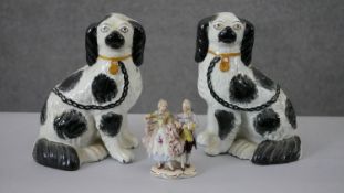 A pair of black and white Staffordshire pottery spaniels along with a hand painted Dresden porcelain