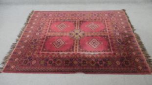An Eastern rug with Hatchli quartered design and lozenge decoration on a burgundy field. L.162 W.140