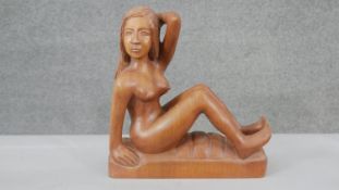 A carved hardwood figure of a nude seated woman on rectangular base. H.28 W.26 D.9cm