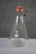 A large Pyrex scientific conical flask with bung. H.43 Diam. 22 cm.