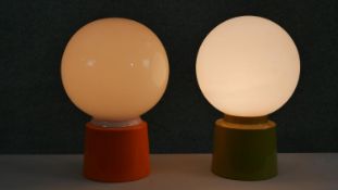 Two mid century green and orange acrylic table lamps with opaque glass white globe shades. H.34 W.