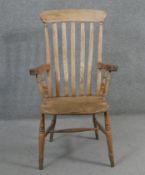 A 19th century elm stick back armchair on turned stretchered supports.