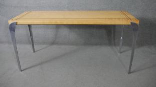 A contemporary birch dining table with geometric inlay raised on shaped brushed chrome supports. H.