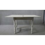A 19th century painted pine fold over top dining table. H.80 W.100 D.66cm (not extended)
