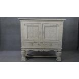 An early 20th century distressed painted 18th century style cabinet with all over carving on