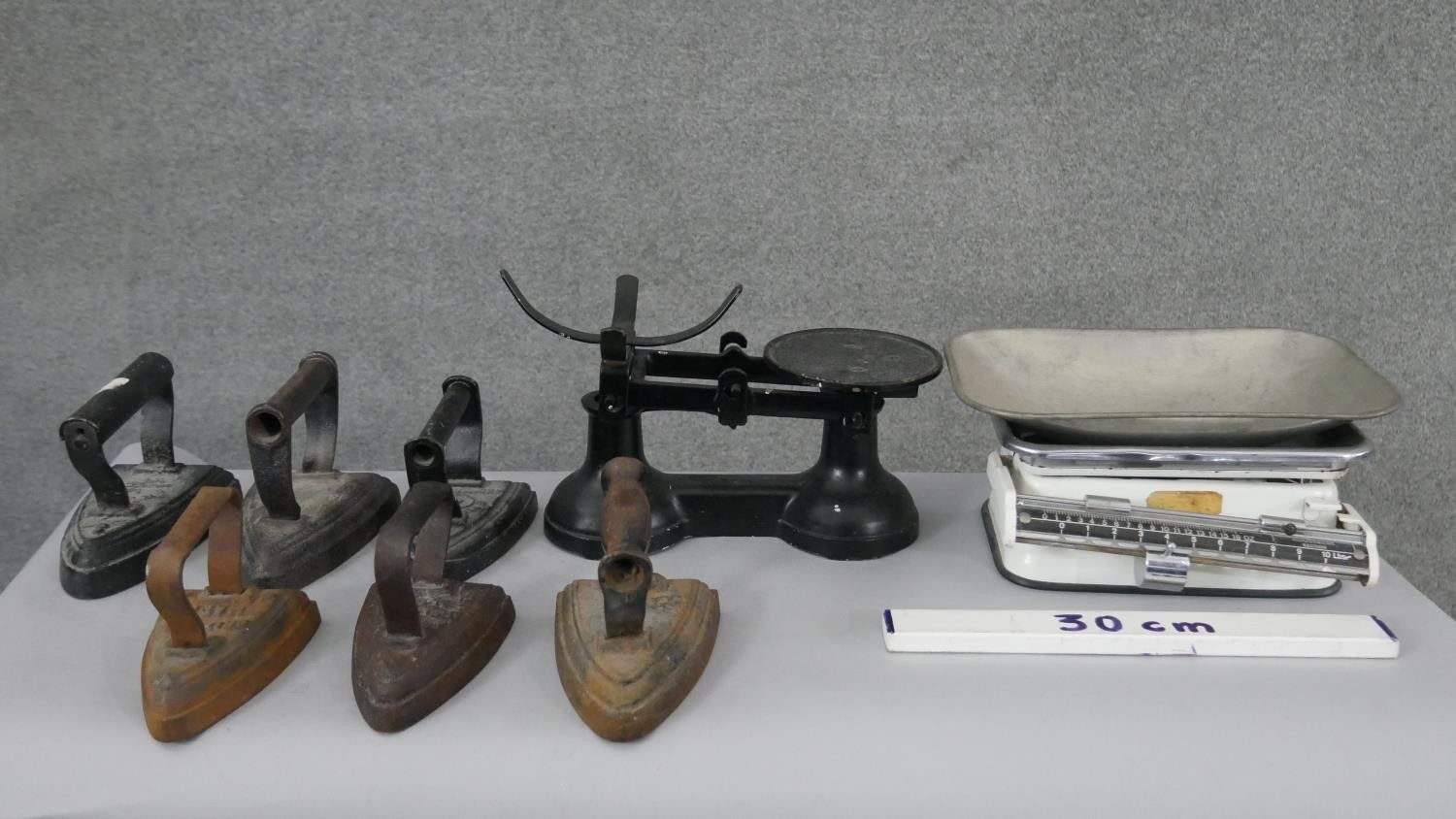A collection of six irons and two sets of shop scales, one by Royal. H.13 W.28 D.17cm (largest) - Image 7 of 7