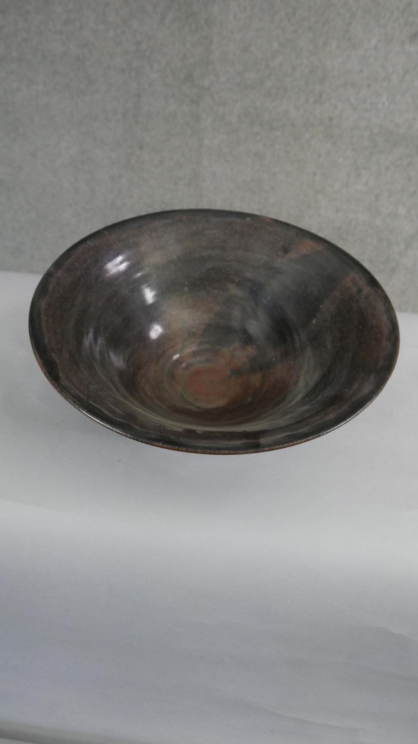 A large footed art pottery bowl with brown and black glaze with flared rim. (Damaged as seen in - Image 2 of 6