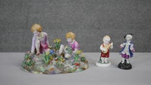 A Crown Staffordshire porcelain hand painted figure group by T.M. Bayley of children picking flowers