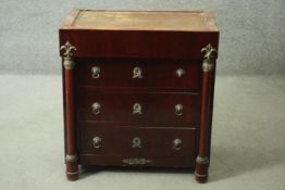 An Empire style ormolu mounted mahogany chest of three long drawers flanked by pilasters on turned
