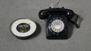 A vintage black dial telephone along with an early 20th century brass barometer with white enamel