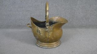 A Victorian brass helmet shaped coal scuttle with hinged swing handle. H.38 W.39 D.27cm