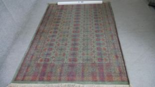 A Bokhara rug with repeating gul motifs on a biscuit ground within multiple borders. L.200 W.140 cm