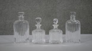 Two sets of cut crystal ridged design decanters and bottles, one pair with original stoppers. H.18
