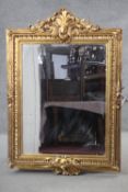 A gilt framed pier mirror with bevelled plate in foliate decorated frame. H.150 W.103 cm.